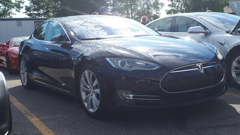 Black Tesla Model S parked in a car park next to a silver Model S