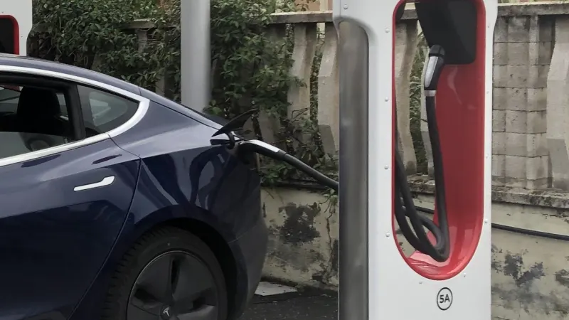 A Tesla Model 3 charging at the dual cable Tesla Supercharger in Imperia, Italy