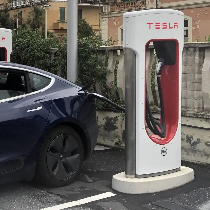 A Tesla Model 3 charging at the dual cable Tesla Supercharger in Imperia, Italy